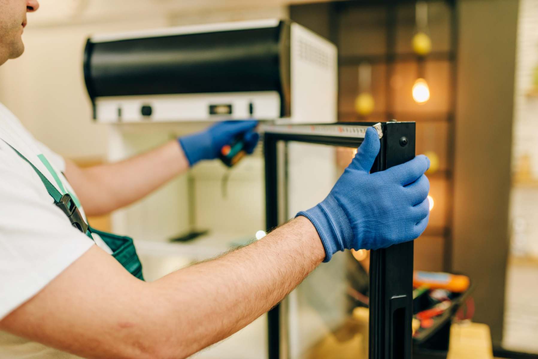 repairman-in-uniform-repairs-refrigerator-at-home-2021-08-26-16-27-07-utc repairs-refrigerator - USS Catering & Refrigeration Equipment Ltd